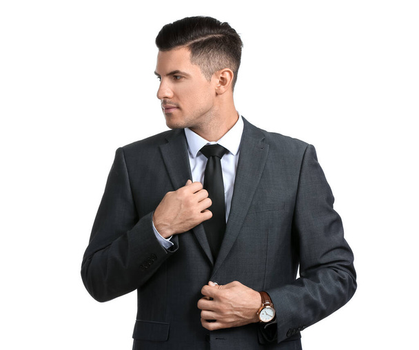 Όμορφος άντρας με επίσημο κοστούμι κοιτάζει πέρα από το λευκό φόντο - Φωτογραφία, εικόνα