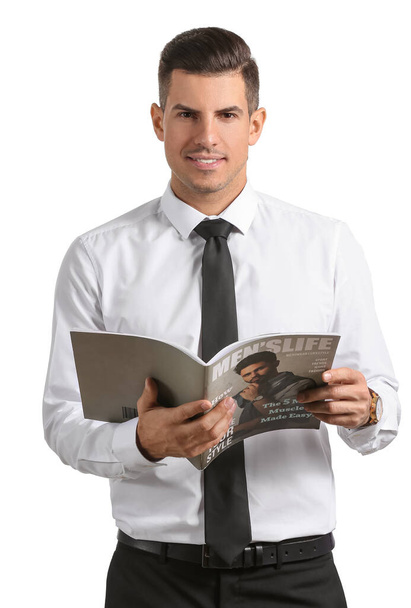 Handsome man in formal clothes holding magazine on white background - Φωτογραφία, εικόνα
