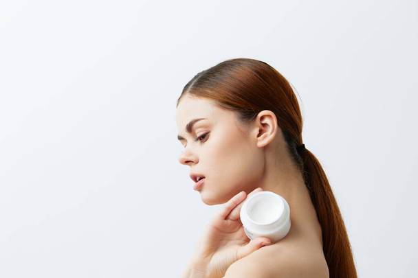 tarro de mujer joven de crema en manos piel limpia posando tratamientos de spa - Foto, Imagen