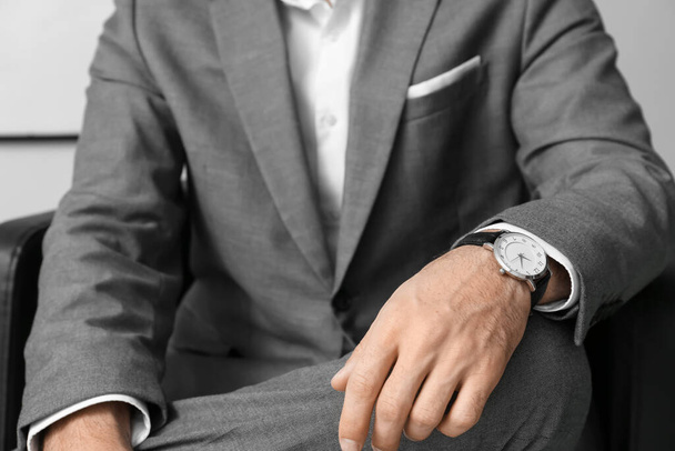 Przystojny mężczyzna w formalnym garniturze i stylowy zegarek siedzący w fotelu, zbliżenie - Zdjęcie, obraz