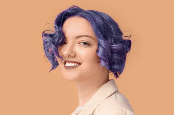 Гарна молода жінка з фіолетовим волоссям на кольоровому тлі. Дуже барвистий 2022 рік - Фото, зображення