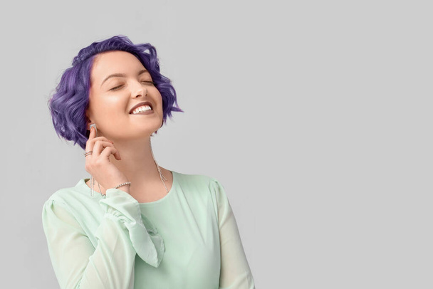 Hermosa joven con pelo violeta sobre fondo claro. Muy Peri - el color del año 2022 - Foto, imagen