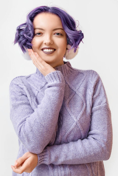 白い背景に紫色の髪とふわふわのヘッドフォンを持つ美しい若い女性。Very Peri - 2022年の色 - 写真・画像