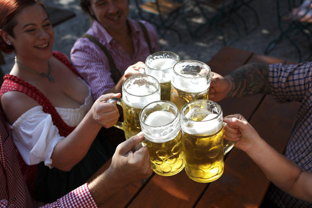 Menschen trinken Bier in einem traditionellen bayerischen Biergarten - Foto, Bild