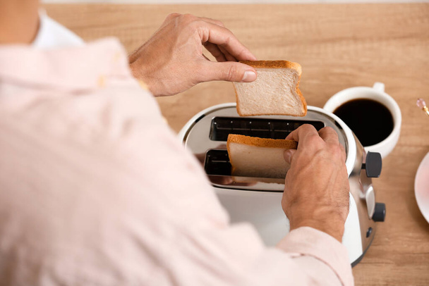 Молодий чоловік робить смачні тости на кухні, крупним планом
 - Фото, зображення