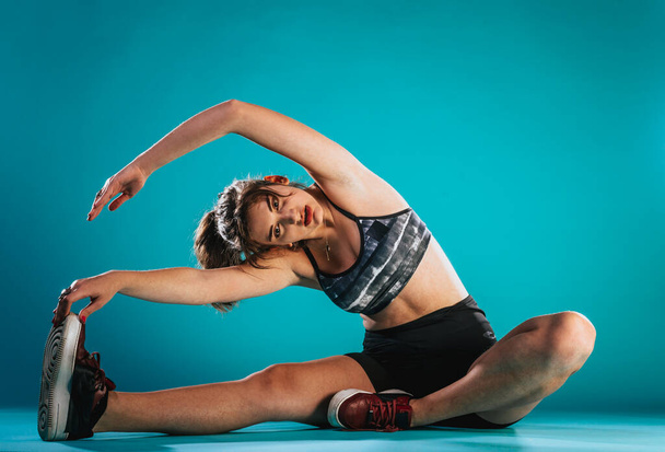 fitness, sport, training, fitness en wellness. Vrouw doet stretching oefeningen in een club - Foto, afbeelding