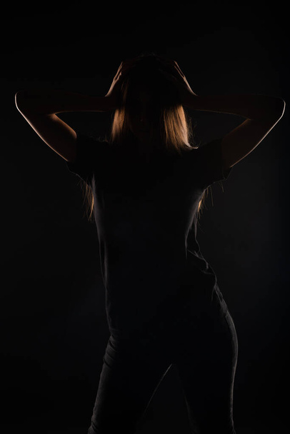 Close up silhouette di un attraente e bella ragazza in posa in studio su sfondo grigio - Foto, immagini