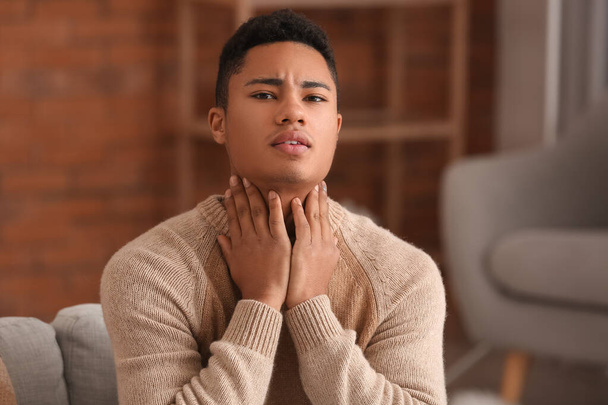 Ill African-American guy with sore throat at home - Fotó, kép