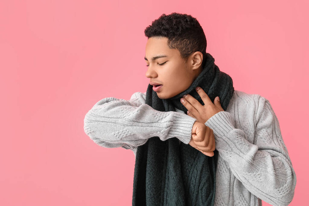 Ill African-American guy with sore throat on color background - Foto, afbeelding