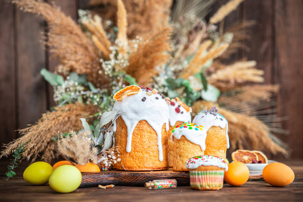 イースターケーキ甘いパン色の装飾自家製ベーキングイースターデザートお祝いの休日を扱う正統派キリスト教のイースターテーブルの上に健康的な食事の軽食を扱うコピースペースフードの背景  - 写真・画像
