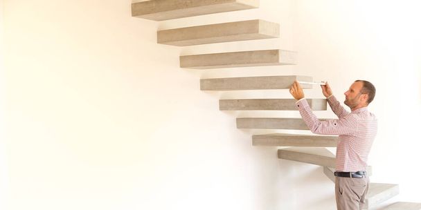 Architect taking measures of a concrete steps staircase. Home style and design concepts - Photo, Image