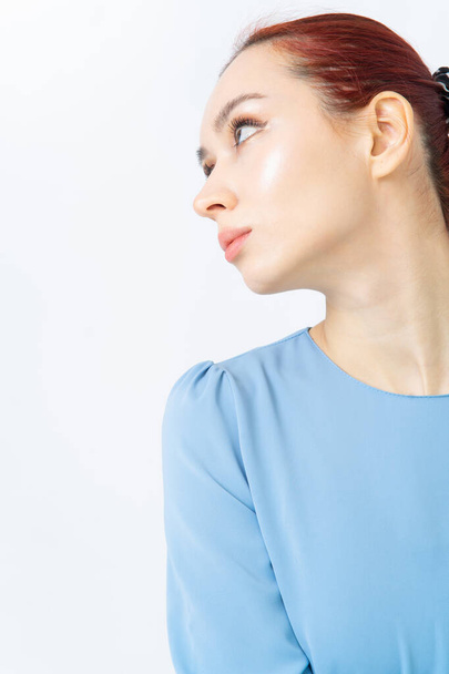 Shoulder of an Asian woman with red hair in a blue summer dress or shirt. Close-up. Clothing made of natural fabrics. White background. - 写真・画像