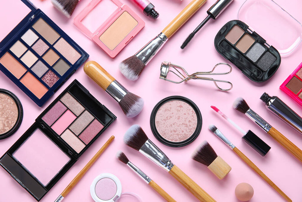Dřevěné make-up kartáče s dekorativní kosmetikou na růžovém pozadí - Fotografie, Obrázek