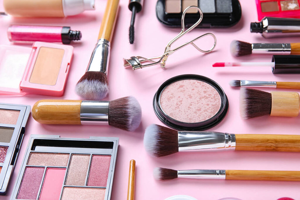 Деревянные щетки для макияжа с декоративной косметикой на розовом фоне, крупным планом - Фото, изображение