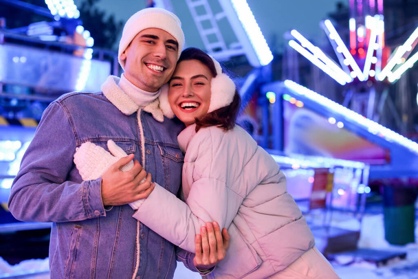 Loving couple in amusement park at winter night - Valokuva, kuva