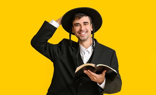 Hasidic Jewish man with Torah on color background - Photo, Image