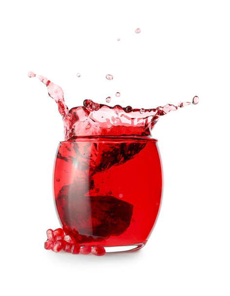 Szklanka smacznego soku z granatu z rozpryskami na białym tle - Zdjęcie, obraz