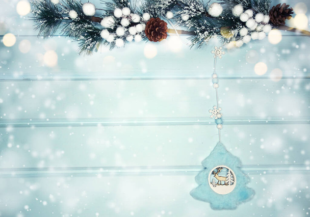 зимовий різдвяний фон з ялиновими гілками конусами та снігом на синій дерев'яній текстурі
                               - Фото, зображення