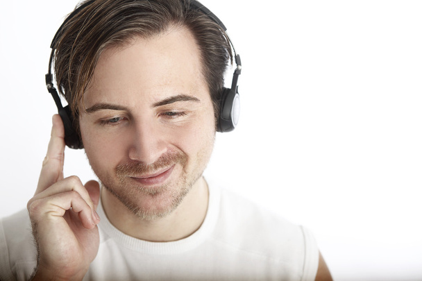 Hombre atractivo con auriculares delante de un fondo blanco es
 - Foto, imagen