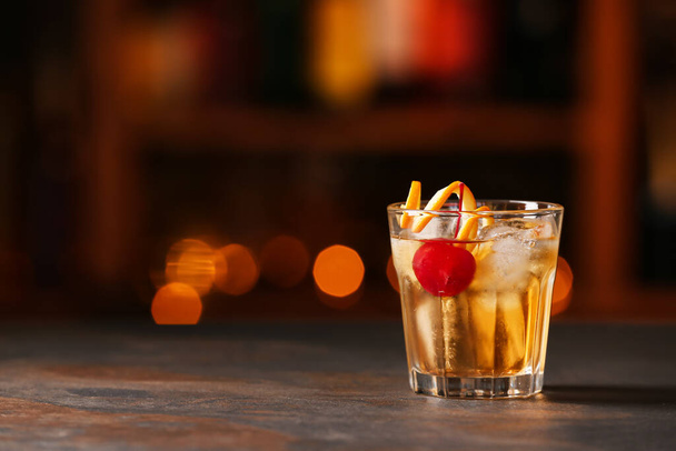 Стакан вкусного старомодного коктейля на столе в баре - Фото, изображение