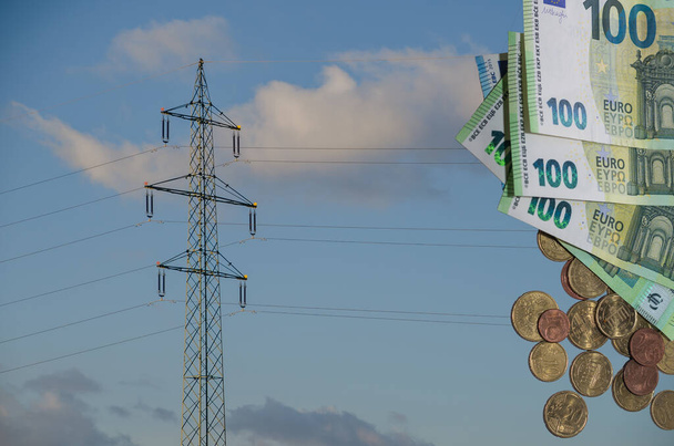 pojedynczy słup elektryczny z wieloma banknotami i monetami o nominale 100 euro dotyczącymi wzrostu cen energii elektrycznej - Zdjęcie, obraz