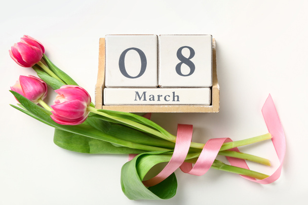 Calendrier avec la date de la Journée internationale de la femme et des fleurs sur fond blanc - Photo, image