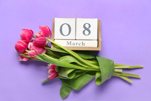 Kalender mit Datum des Internationalen Frauentages und Blumen auf violettem Hintergrund - Foto, Bild