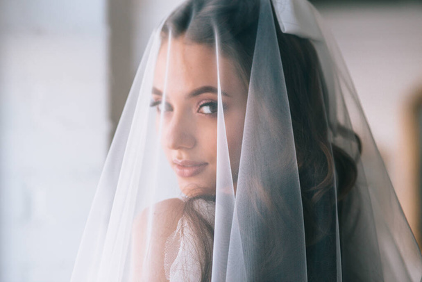 Beautiful bride portrait with veil over her face. Closeup portrait of young gorgeous bride. Wedding. - Φωτογραφία, εικόνα