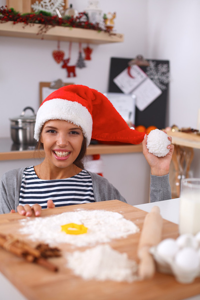 Happy young woman smiling happy having fun with Christmas preparations wearing Santa hat - Fotografie, Obrázek