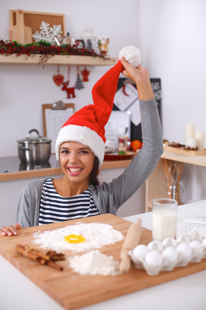 Happy young woman smiling happy having fun with Christmas preparations wearing Santa hat - Φωτογραφία, εικόνα