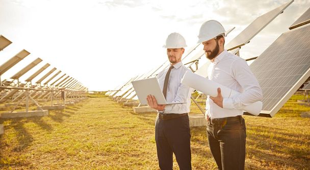 Engineers working in field with solar panels - Фото, зображення