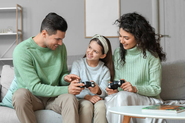 Szczęśliwa rodzina w ciepłych swetrach z podkładkami do gry w domu - Zdjęcie, obraz