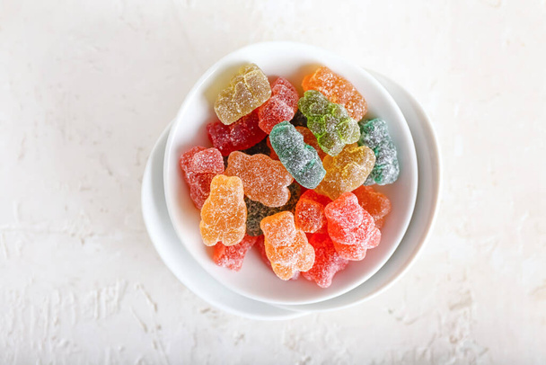 Bowls with tasty jelly bears on light background - Foto, Imagen