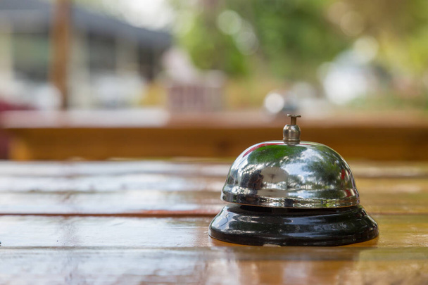 Bell on the wood table in restaurant with nature background - Photo, Image