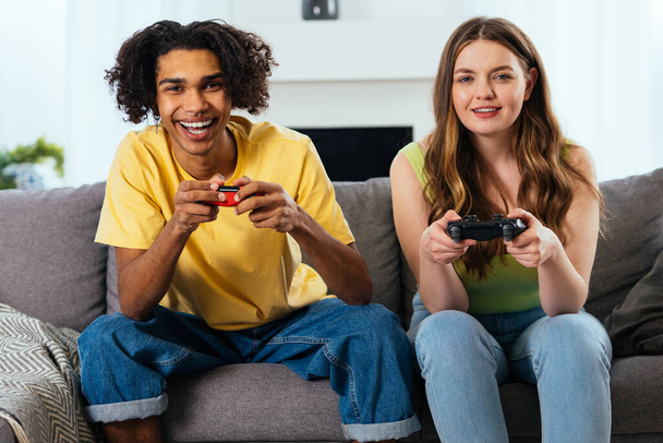 modern multiethnic unstereotyped couple playing videogames at home. Not stereotyped boyfriend and girlfriend living together. True love concepts - Zdjęcie, obraz