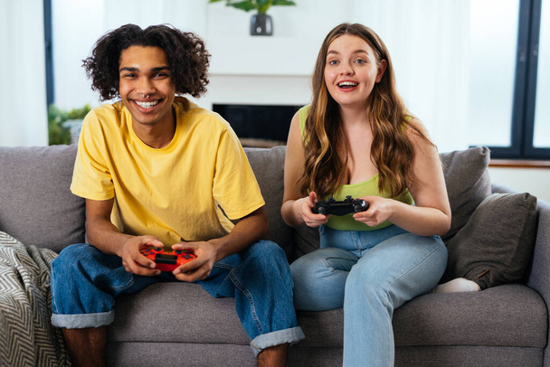 modern multiethnic unstereotyped couple playing videogames at home. Not stereotyped boyfriend and girlfriend living together. True love concepts - Fotó, kép