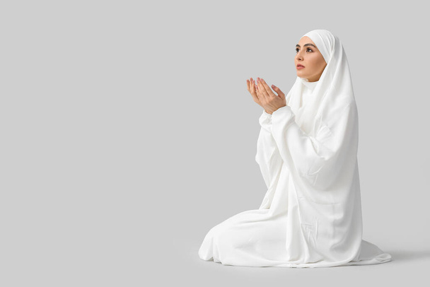 Muslim woman praying on light background - Photo, Image