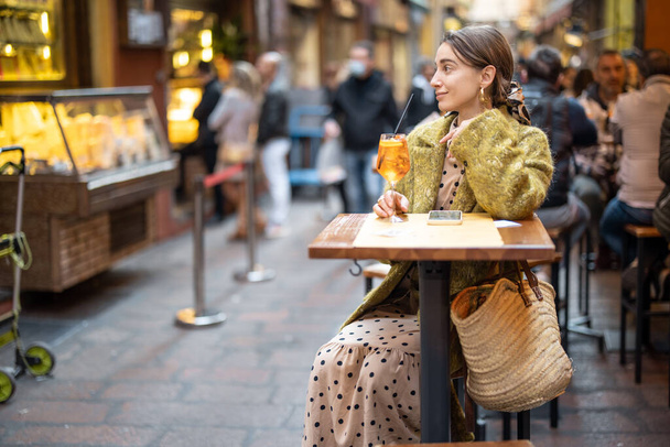 Nainen cocktailin kanssa ulkona baarissa tai ravintolassa Bolognassa - Valokuva, kuva