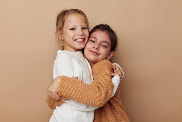 two girlfriends together kids fun studio beige background - Valokuva, kuva