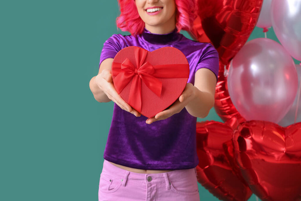 Статильна жінка з яскравим волоссям, подарунком і повітряними кулями на кольоровому фоні. День святого Валентина. - Фото, зображення