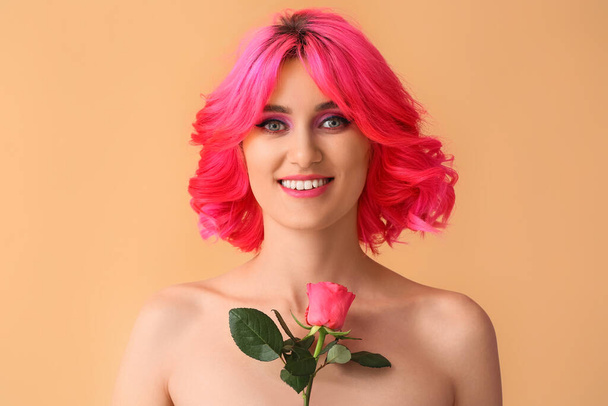 Stílusos nő fényes haj és rózsa virág a színes háttér - Fotó, kép