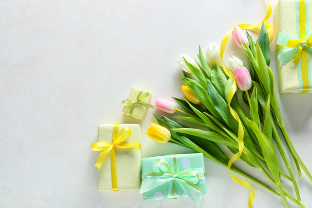 Composition avec boîtes cadeaux et fleurs pour la célébration de la Journée internationale de la femme sur fond blanc - Photo, image