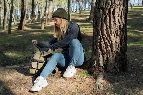 Young woman resting in the wood after a long trekking day - Foto, Bild