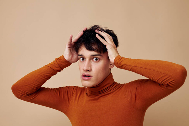 portrait of a young man posing in brown sweater self confidence fashion light background unaltered - Фото, зображення