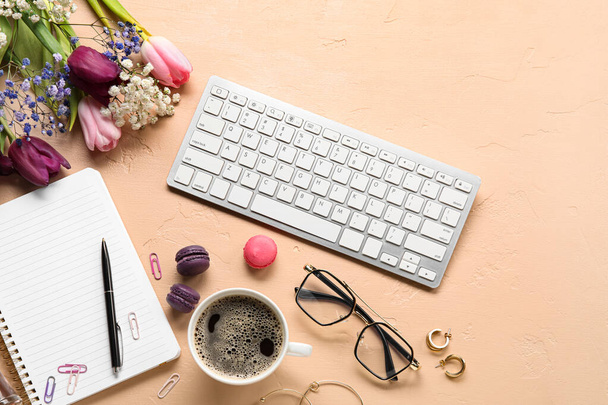 Samenstelling met toetsenbord, kopje koffie, vrouwelijke accessoires en mooie bloemen op kleur achtergrond - Foto, afbeelding