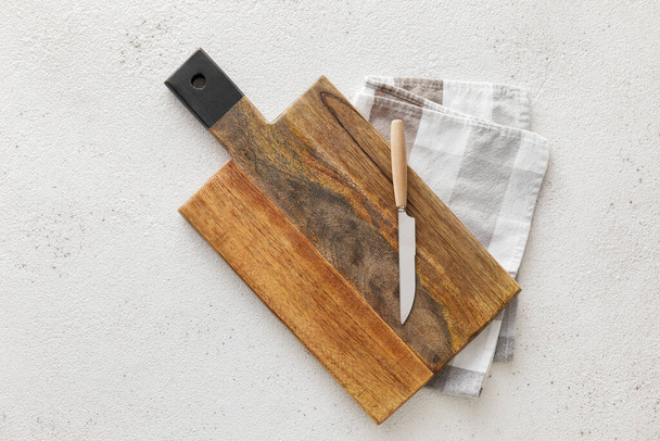 Wooden cutting board, knife and napkin on white background - Photo, Image