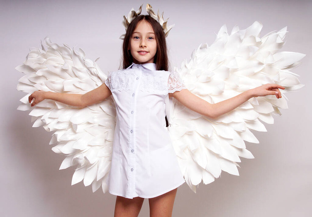 Pretty young lady with angel wings.Isolated studio shot - 写真・画像