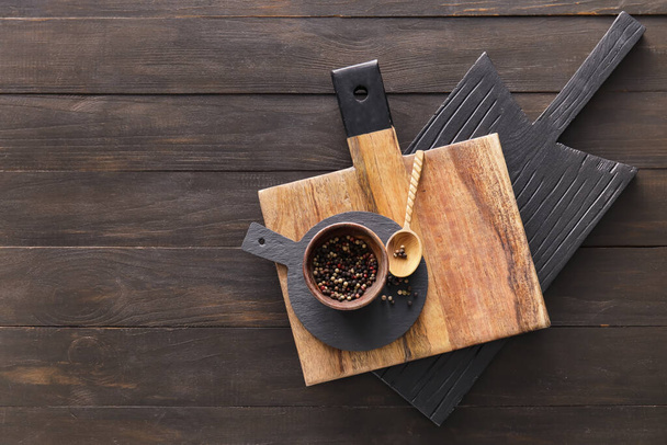 Tablas de cortar y tazón con pimienta sobre fondo de madera oscura - Foto, Imagen