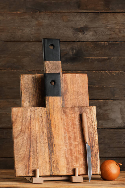 Tábuas de corte, faca e cebola sobre fundo de madeira - Foto, Imagem