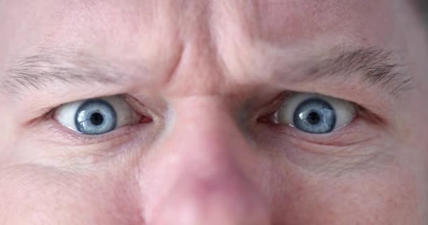 Przerażony zszokowany wygląd mężczyzna z niebieskimi oczami zbliżenie - Materiał filmowy, wideo